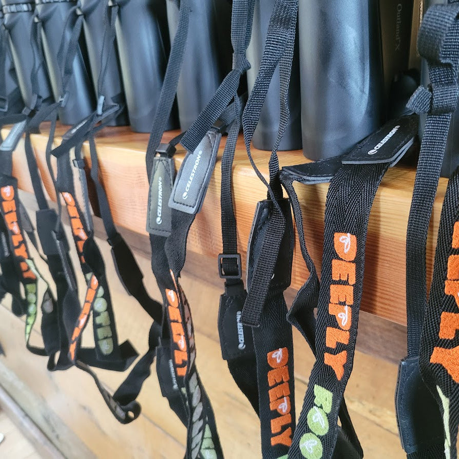 Row of black straps with orange text on a wooden surface